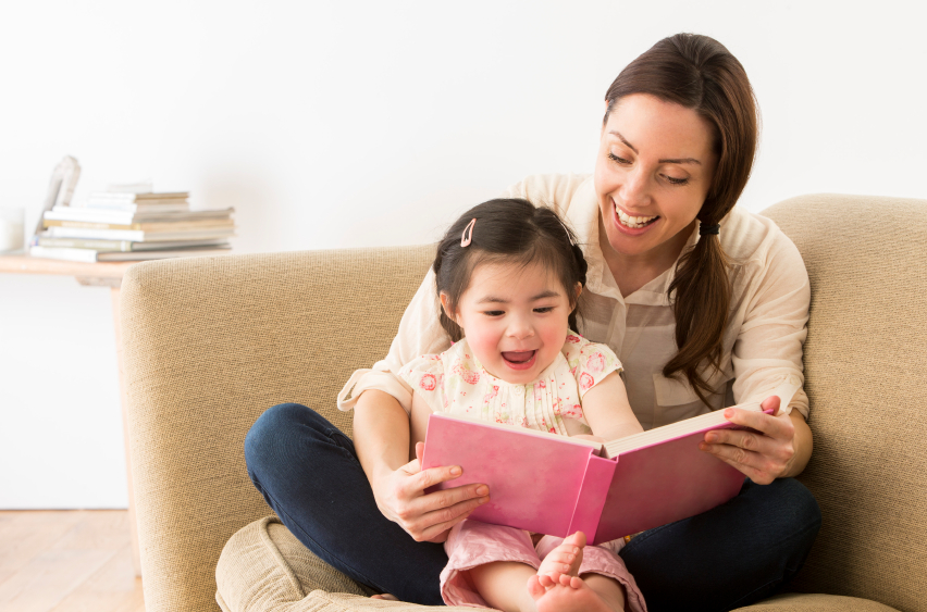 babysitter with asian child reading inside small